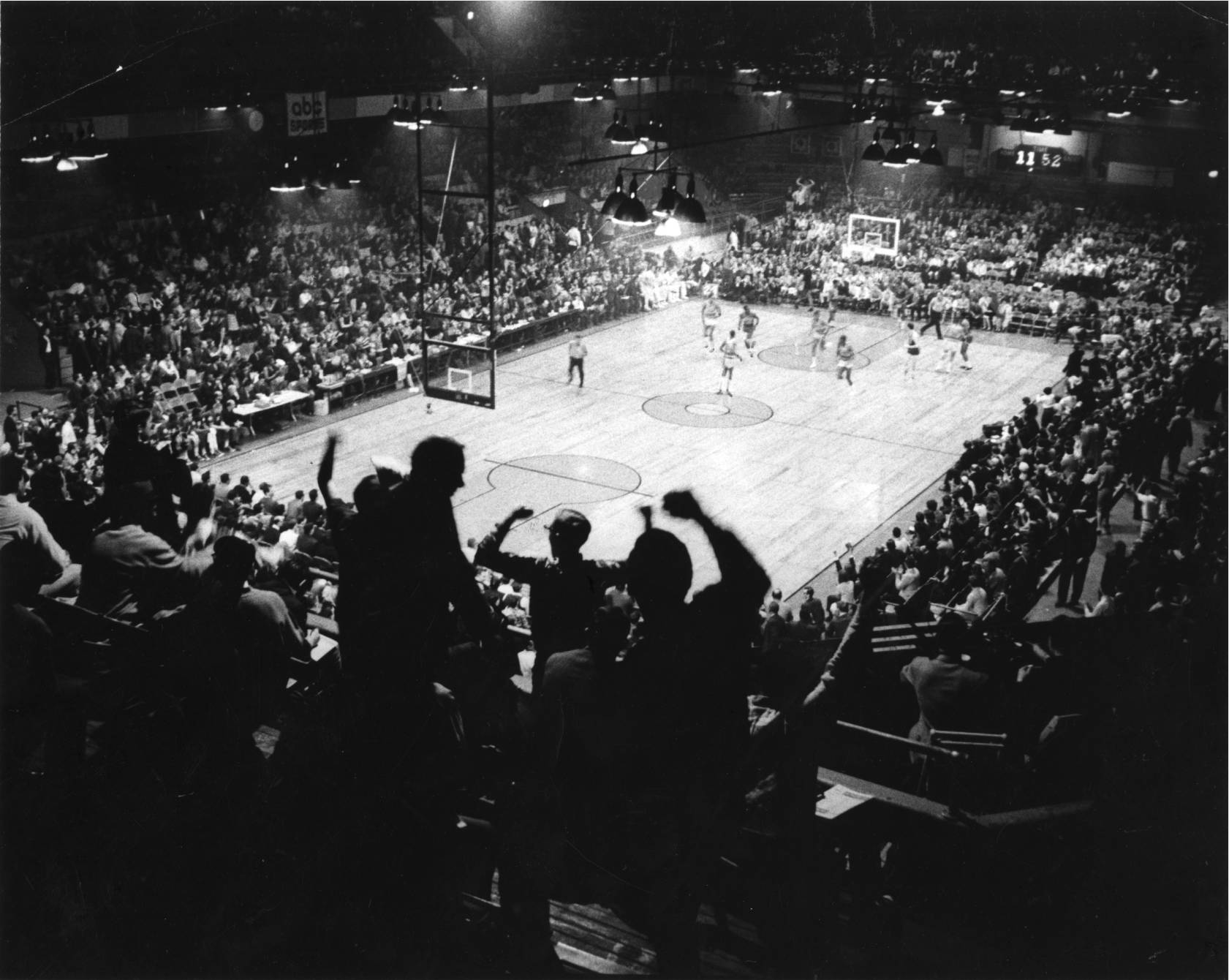 Excited spectators pack the stands of the Arena at a 1966 76ers and Celtics game.