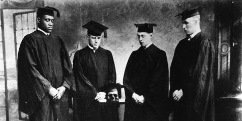 Black and white photo of Robeson and three other Rutgers scholars standing in their academic caps and gowns