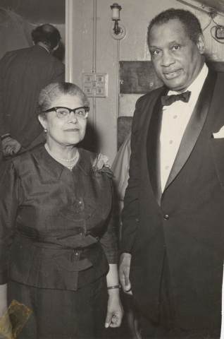Black and white photo of Essie and Paul Robeson in formal attire. Essie wears glasses in this photo.