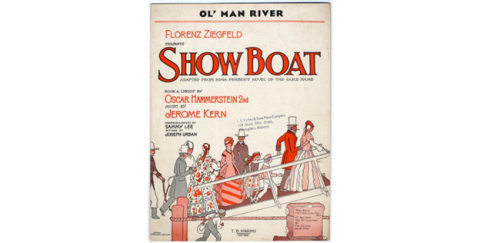 Photo of a copy of the original  sheet music and lyrics for the song “Ol’ Man River”, which Paul Robeson controversially sang in his role as Joe the Riverman, in the 1927 play Show Boat. The letters “Show Boat” appear in orange type above a group of men, women, and children bedecked in vintage hats and bonnets ascending a gangplank.