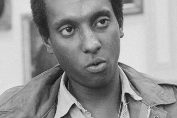 Black and white photo of Stokely Carmichael, the future Kwame Ture, when he was chairman of the Student Non-Violent Coordinating Committee (SNCC, pronounced “SNICK”). This photo from 1966 shows Carmichael in Mississippi wearing blue denim overalls in solidarity with poor Black tenant farmers and Black working people generally.