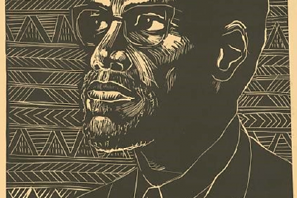 Black and white linoleum print of Malcolm X with his short circle beard and eyeglasses. Print in the foreground reads MALCOLM X. His name and image are framed by horizontally arranged African cultural symbols.