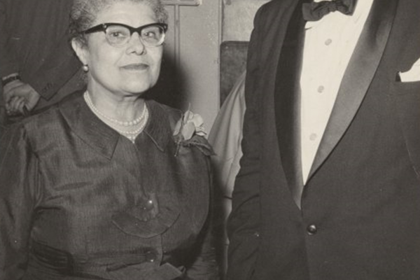 Black and white photo of Essie and Paul Robeson in formal attire. Essie wears glasses in this photo.